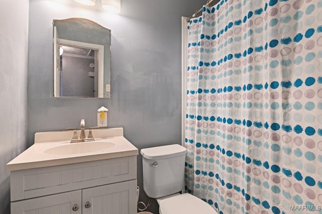 full bath featuring toilet, vanity, and a shower with curtain