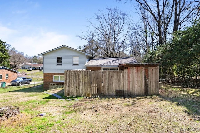 back of house featuring a yard and brick siding