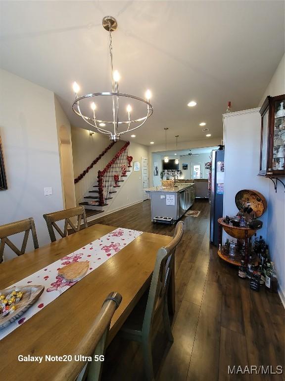 dining area featuring recessed lighting, a chandelier, dark wood-style floors, and stairs