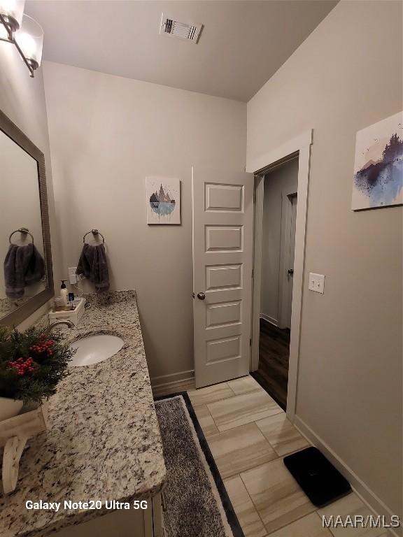 bathroom with vanity, baseboards, visible vents, and wood tiled floor