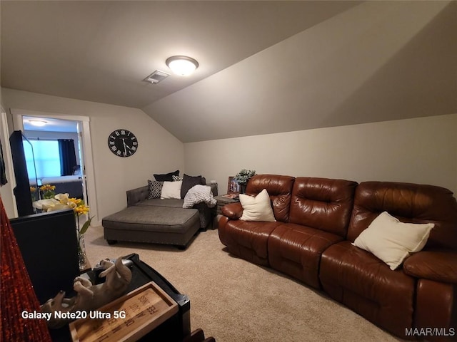 carpeted living room with visible vents and lofted ceiling