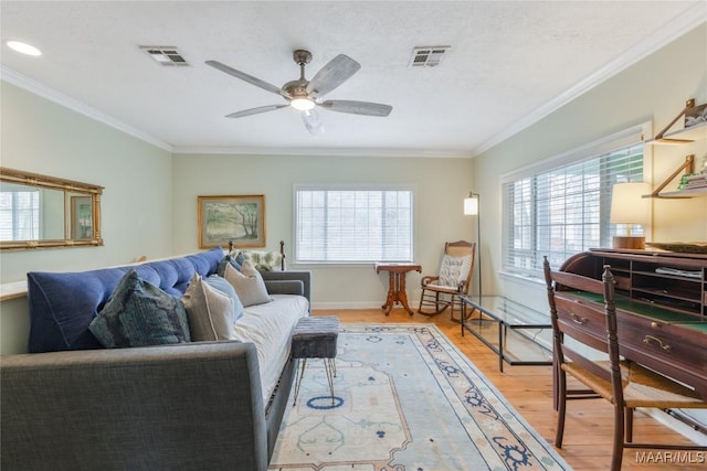 living area with a healthy amount of sunlight, visible vents, and ornamental molding