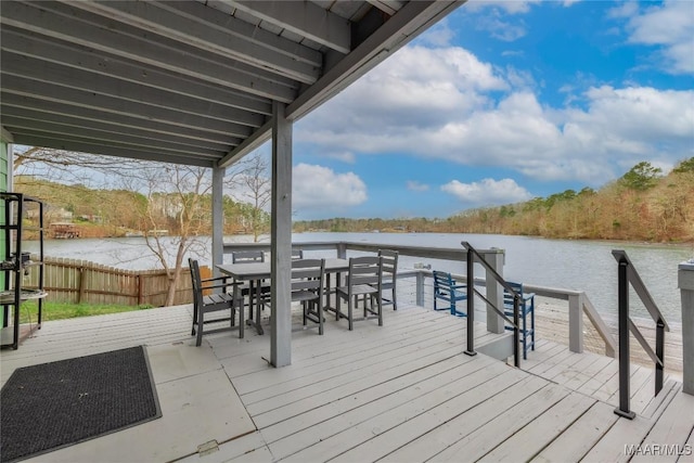 dock area with outdoor dining space and a deck with water view