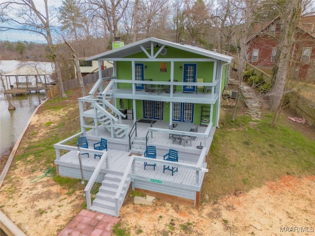 exterior space with stairway, a water view, and a chimney