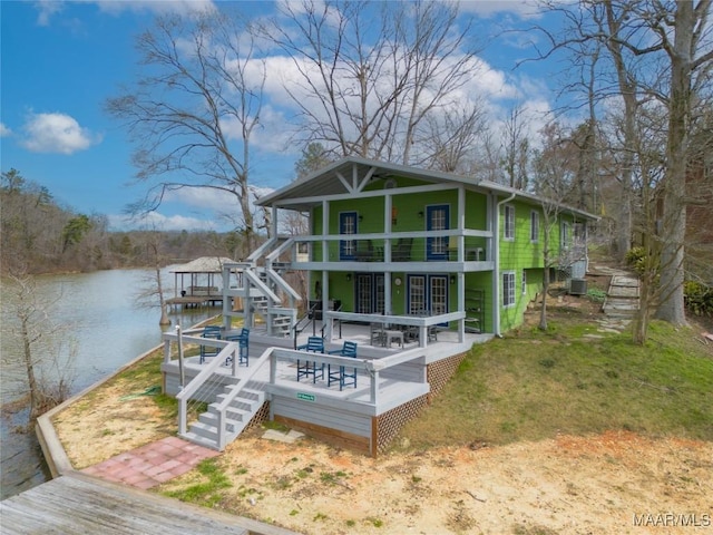 rear view of property with stairway, central AC unit, and a deck with water view