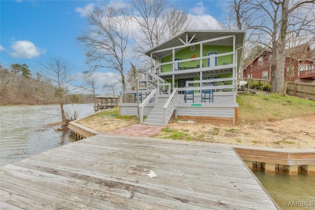 view of dock featuring a deck with water view and fence