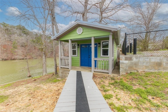 view of outdoor structure with covered porch and fence