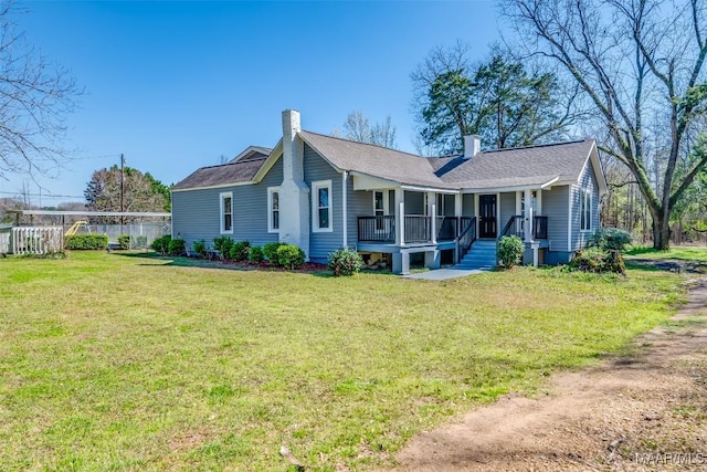 view of front facade featuring a porch, a front lawn, and a chimney