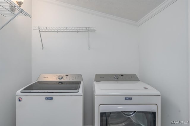 laundry room featuring ornamental molding, laundry area, and washing machine and clothes dryer