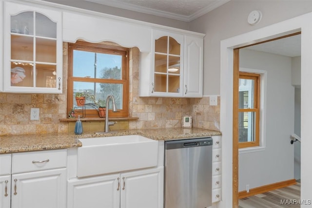 kitchen with a sink, white cabinets, glass insert cabinets, dishwasher, and backsplash