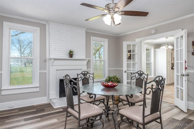 dining space with french doors, light wood-type flooring, and ornamental molding