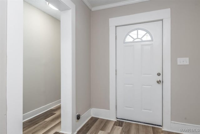 foyer featuring ornamental molding, baseboards, and wood finished floors