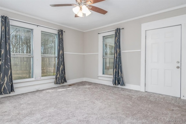 carpeted spare room featuring ceiling fan, baseboards, and ornamental molding