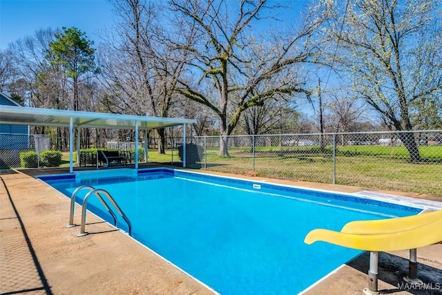 view of pool with a fenced in pool, a lawn, a water slide, and fence