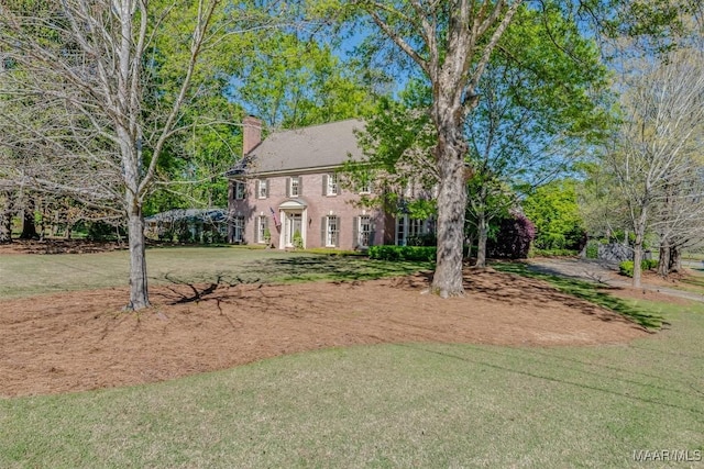 view of front of property featuring a front yard and a chimney