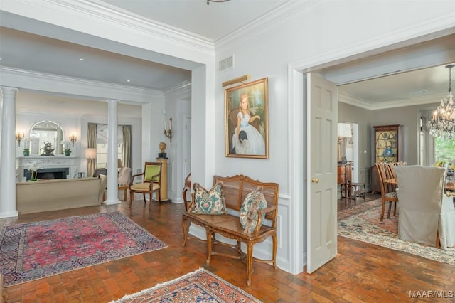 interior space featuring a notable chandelier, brick floor, and ornate columns