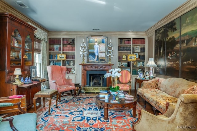 living area featuring built in features, visible vents, ornamental molding, and a fireplace