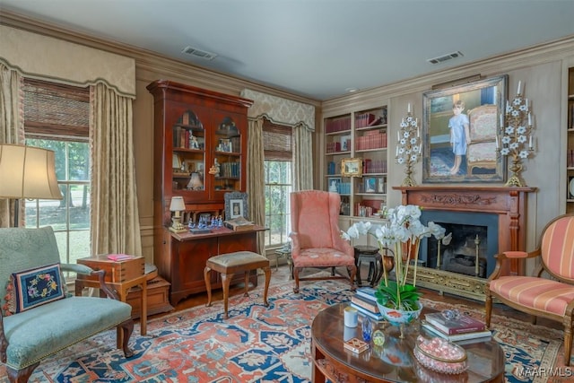 sitting room with crown molding, a fireplace, and visible vents