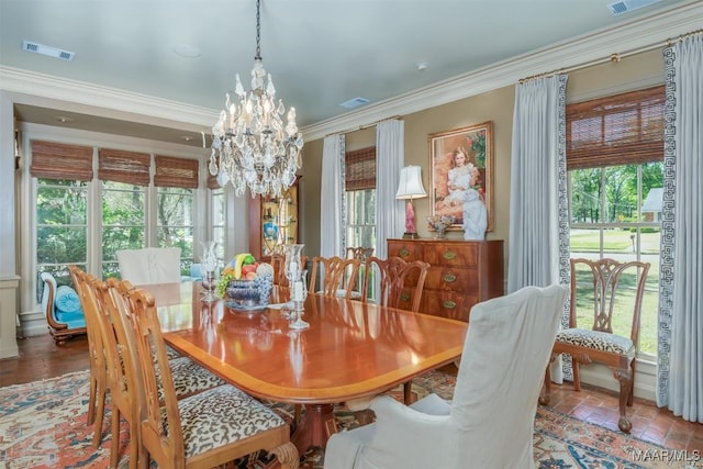 dining area with visible vents, an inviting chandelier, and ornamental molding