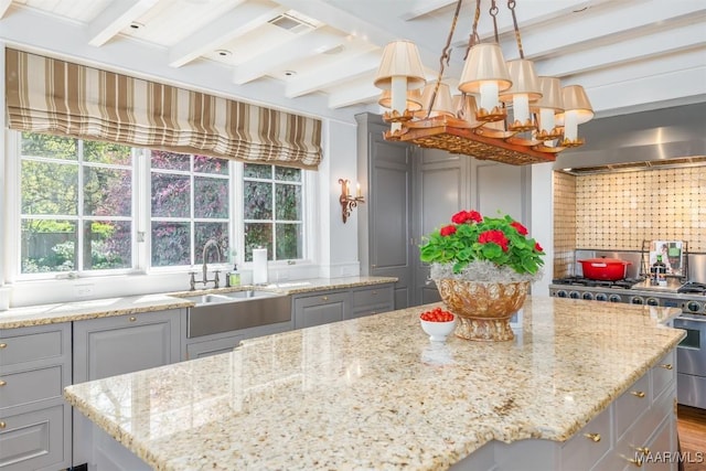 kitchen with beamed ceiling, gray cabinetry, and high end stove