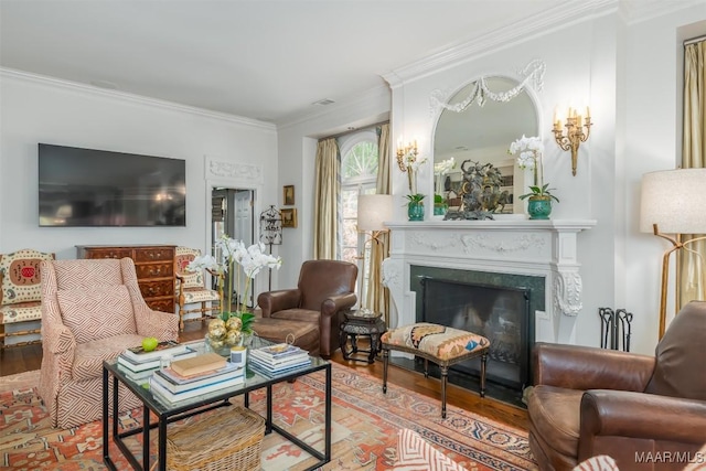 living room featuring visible vents, a fireplace, crown molding, and wood finished floors