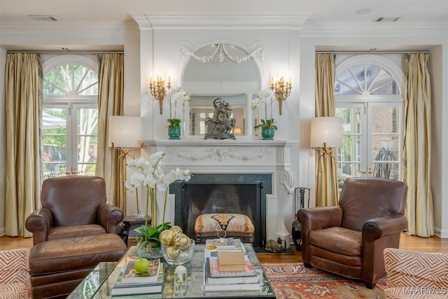 sitting room featuring visible vents, ornamental molding, a fireplace, and wood finished floors