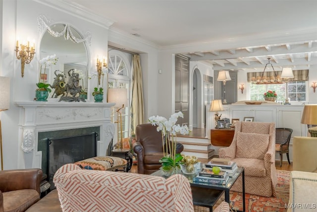 living area featuring wood finished floors, a fireplace, arched walkways, crown molding, and beamed ceiling