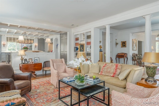 living area featuring built in features, wood finished floors, ornate columns, arched walkways, and ornamental molding