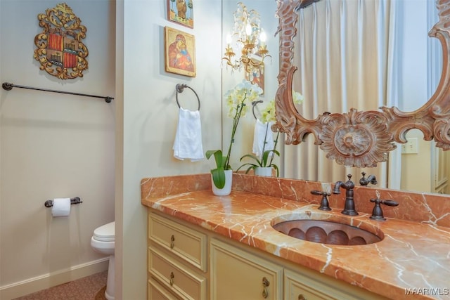 bathroom with baseboards, toilet, and vanity