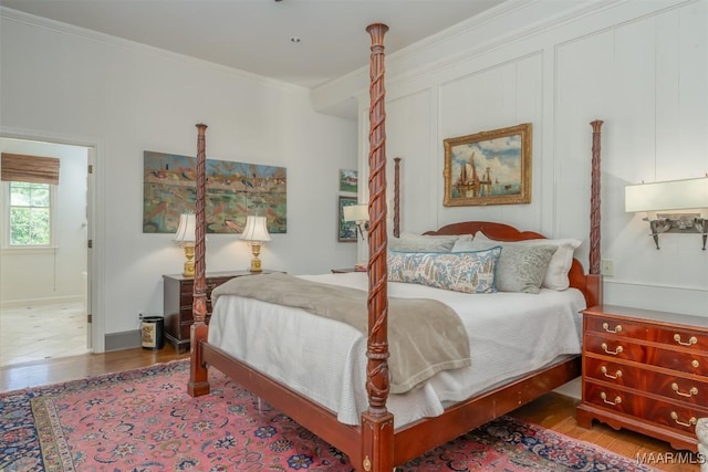 bedroom with crown molding and wood finished floors