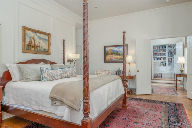 bedroom featuring wood finished floors and ornamental molding