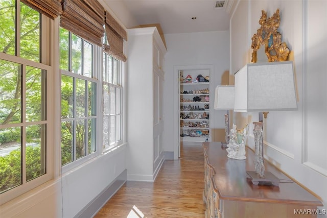 corridor with visible vents and light wood finished floors