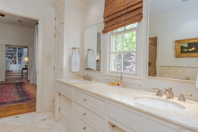 bathroom with a sink, double vanity, and tile patterned flooring