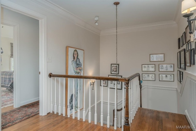 stairs featuring crown molding, wood finished floors, and baseboards