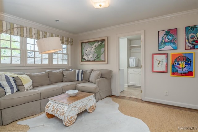 living room featuring baseboards, wood finished floors, and ornamental molding