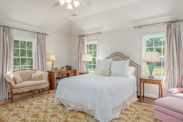 bedroom featuring light wood finished floors, visible vents, and a ceiling fan