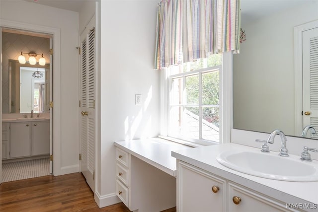 full bath with a sink, a closet, and wood finished floors