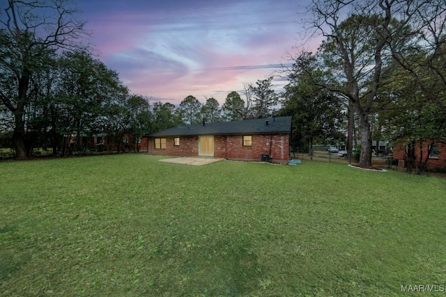 yard at dusk featuring a patio and fence