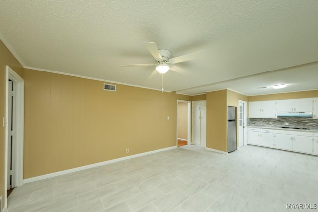 unfurnished living room with visible vents, a textured ceiling, crown molding, and ceiling fan