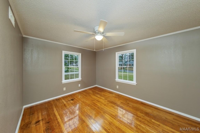 unfurnished room featuring hardwood / wood-style flooring, plenty of natural light, baseboards, and ornamental molding