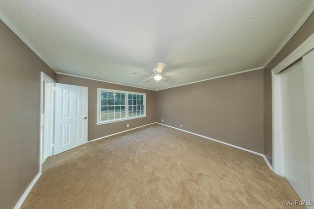 unfurnished bedroom with crown molding, baseboards, carpet floors, and a textured ceiling