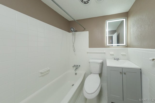 full bath with tub / shower combination, toilet, tile walls, and vanity