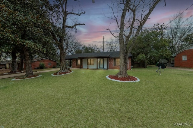 view of front of house featuring brick siding and a front lawn