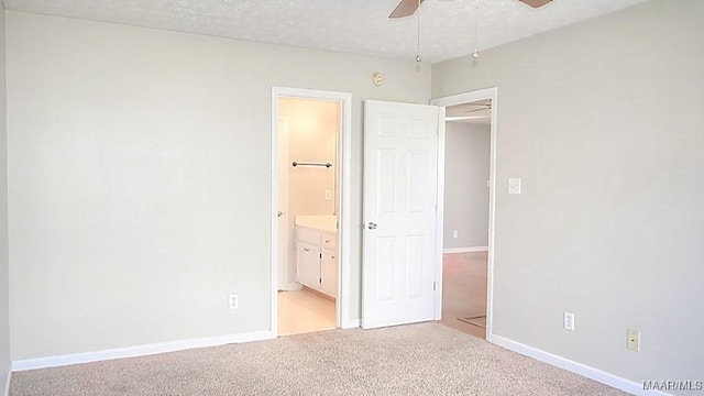 unfurnished bedroom with connected bathroom, ceiling fan, baseboards, carpet floors, and a textured ceiling