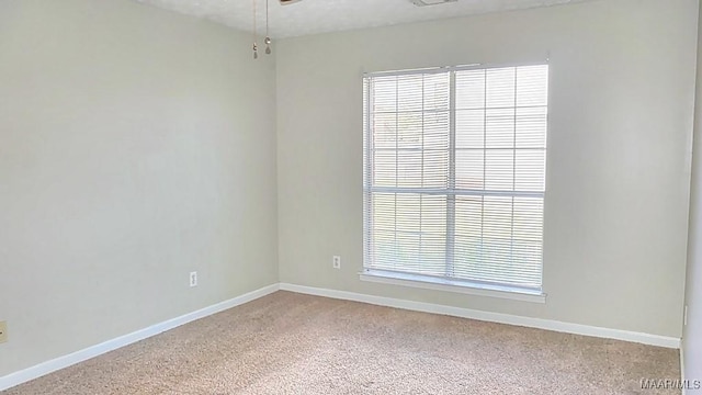 spare room with light carpet, visible vents, and baseboards