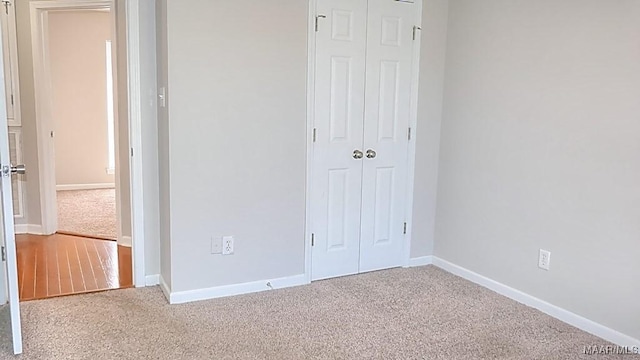 unfurnished bedroom featuring a closet, baseboards, and carpet floors