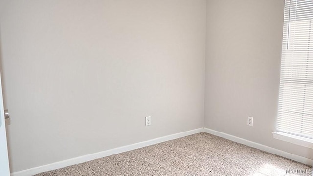 spare room with light carpet and baseboards