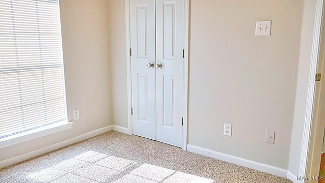 unfurnished bedroom with a closet, baseboards, and carpet