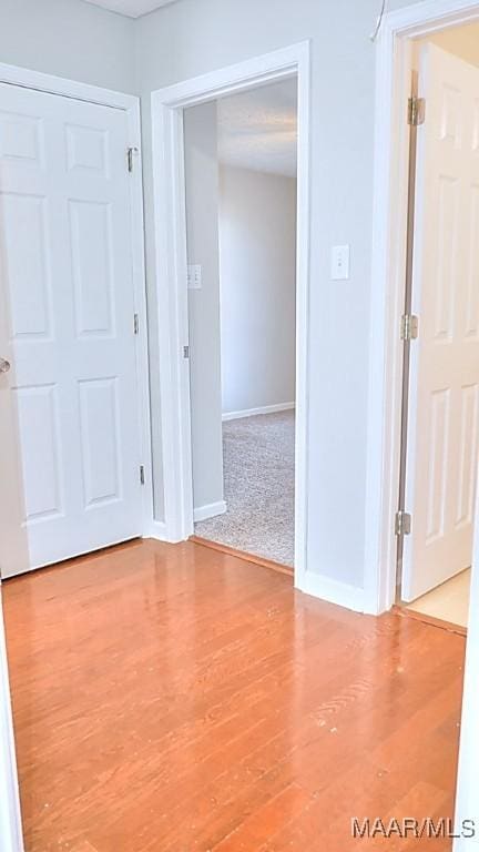 spare room featuring baseboards and wood finished floors