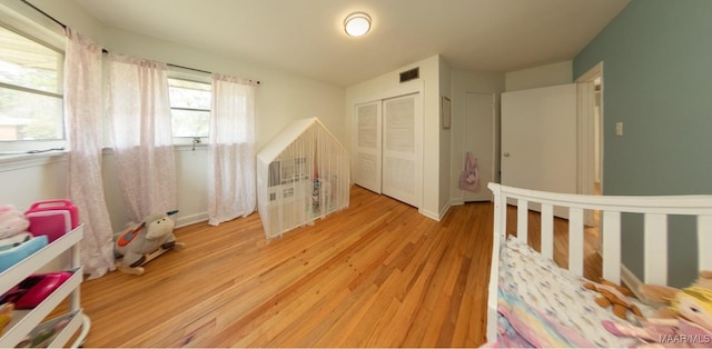 unfurnished bedroom with visible vents, baseboards, light wood-style floors, and a closet